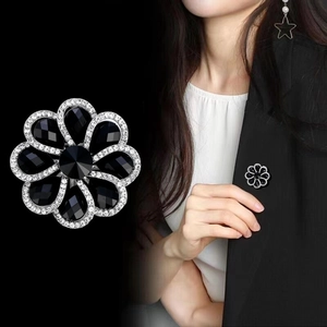 Elegant silver flower brooch with black teardrop crystals and white pavé accents