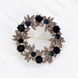 Elegant wreath brooch with deep blue crystals and champagne rhinestones in vintage silver