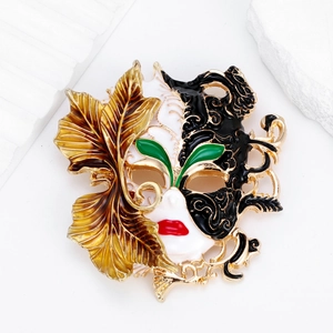 Vintage Chinese mask brooch with black and white enamel and golden autumn leaf accent