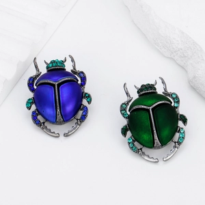 Squisita spilla a scarabeo blu e verde con finitura opaca e cristalli su bianco