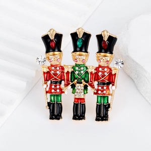 Three nutcracker soldier brooches with enamel finish and sparkling crystal accents
