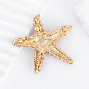 Back view of gold starfish brooch with brushed metal texture and secure safety pin clasp