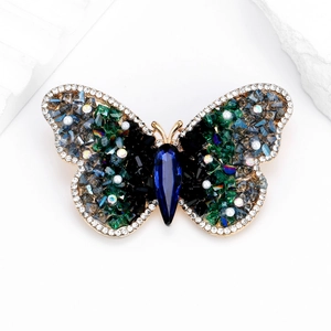 Eleganter Schmetterlings-Kristallbrosche mit Smaragd- und Blausteinen auf Goldmetall