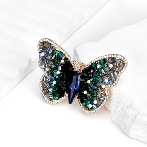 Exquisite Brosche in Schmetterlingsform mit blauen Kristallen und goldenem Metallrand