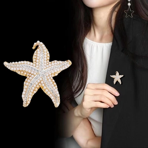 Broche étoile de mer glamour avec strass étincelants et perles sur veste noire
