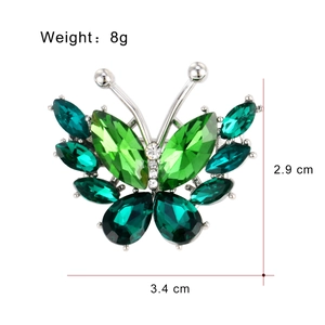 Minimalist crystal butterfly brooch with green rhinestones and silver metal finish