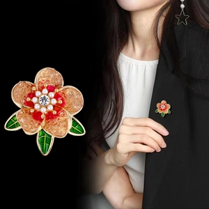 Élégante broche fleur de pivoine avec pétales ambrés et perles sur fond noir