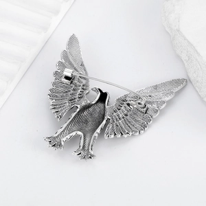 Vintage silver eagle brooch pin with spreading wings shown on a white aesthetic background