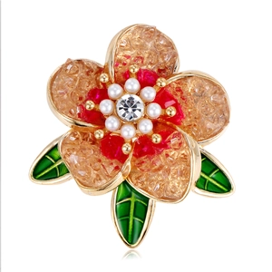 Broche fleur vintage française avec pétales ambre, perles et feuilles vertes sur fond blanc pur