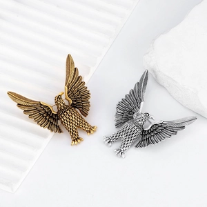Vintage eagle brooch set in gold and silver finish with detailed wing feather texture