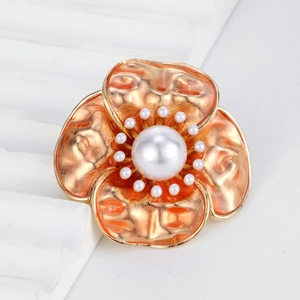 Vintage orange enamel camellia flower brooch with pearl center on white stone pedestal