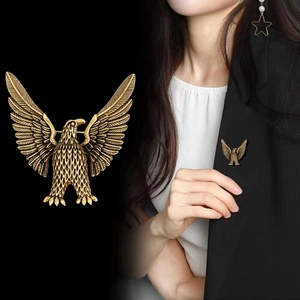Vintage golden eagle brooch with spreading wings on a black suit lapel for elegant styling