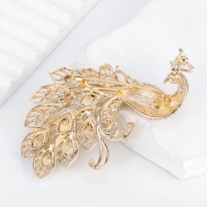 Back view of gold peacock brooch showing the secure safety pin and hollow metalwork