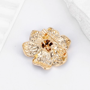 Back view of elegant gold camellia flower brooch showing secure pin clasp mechanism