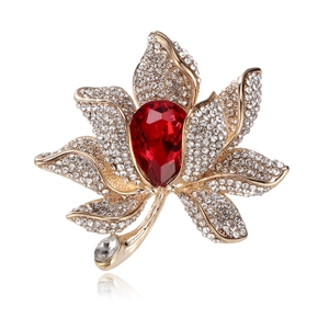Macro detail of maple leaf brooch with red pear-cut crystal and gold-tone pavé rhinestones
