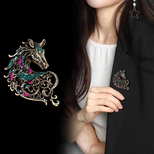 Vintage horse brooch in antique gold with colorful crystals on a black suit lapel