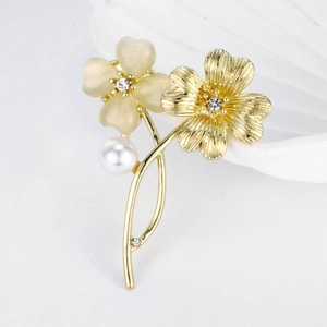 Spilla floreale elegante con petali gialli, trama dorata, strass e perla bianca