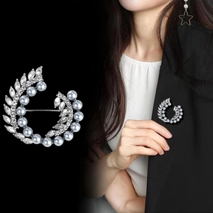 Elegante broche de corona con perlas azul claro y diamantes sobre base de metal plateado