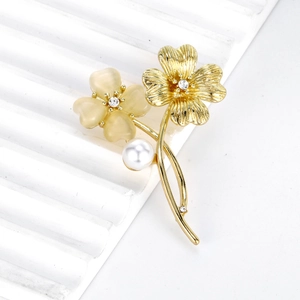 Elegante spilla floreale con fiore giallo traslucido, petali dorati e perla bianca