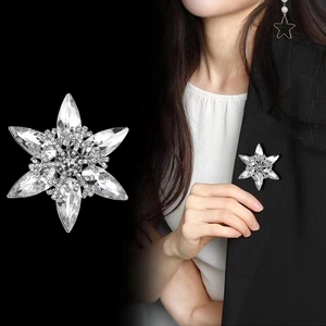 Sparkling silver snowflake brooch with crystals on a black suit lapel for women
