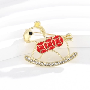 Elegant gold rocking horse brooch with red coins and sparkling crystals on a white pedestal