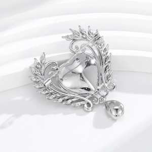 Silver vintage heart brooch with intricate carvings and elegant teardrop pendant