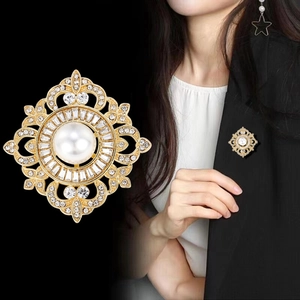 Vue macro détaillée et photo portée d'une broche de style palais avec perle et strass