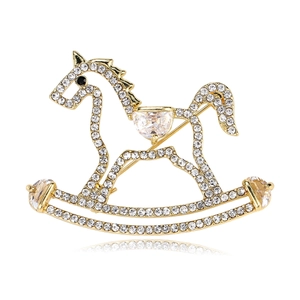 Détail d'une broche cheval à bascule dorée avec pavé de cristaux blancs et pierres fines