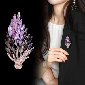 Macro detail and on-suit view of an elegant wheat ear brooch with purple crystals