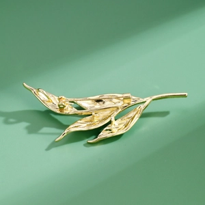 Elegant gold leaf branch brooch with translucent green enamel and secure rotating pin