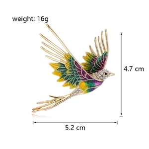 Elegant enamel flying bird brooch with colorful wings and crystals in golden finish