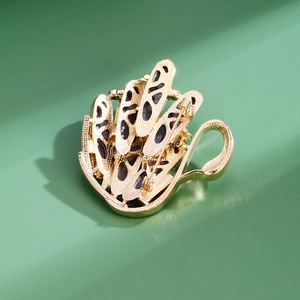 Elegant gold-plated crystal swan brooch with textured finish and black cutout accents