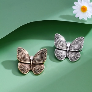 Vintage gold and silver butterfly brooches with spiral textures and crystal inlay