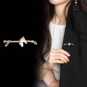 Vintage golden horse head brooch pin displayed on black suit lapel for elegant styling