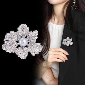 Broche fleur argentée élégante avec strass blancs et détail de perle centrale