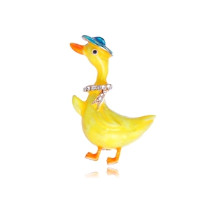 Cute yellow cartoon duck brooch with blue hat and rhinestones on white background