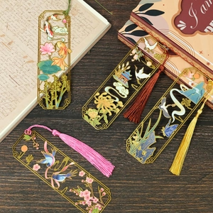 Detailed close-up of hollow metal bookmarks with colorful tassels on vintage paper