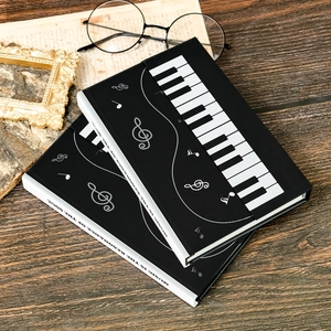 Creative piano themed hardback notebooks with silver music notes on a dark wood background