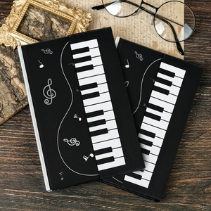 Artistic piano themed hardcover notebook with musical keys on a rustic wood background