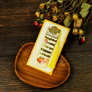 Detail of golden hollow metal bookmark with yellow tassel and inspirational quote
