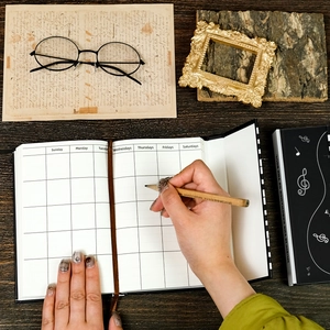Music-themed hard cover notebook featuring a creative piano design and weekly planner layout