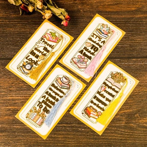 Set of four metal bookmarks with colorful tassels and inspiring quotes on wood background