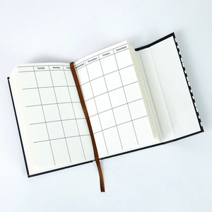Detail view of piano themed magnetic notebook showing white planner pages with brown ribbon