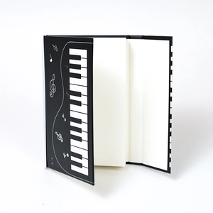 Vertical view of a piano theme notebook showing the musical cover and thick inner pages