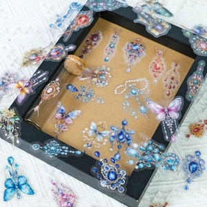 Macro detail of vintage jewel and butterfly PET stickers used for artistic scrapbooking decoration