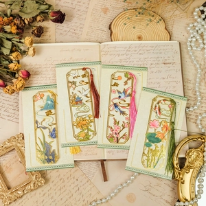 Macro detail of four hollow metal bookmarks with silk tassels and traditional motifs