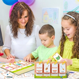 Teacher and children interact with English learning cards on a green tabletop display