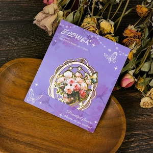 Dettaglio di un segnalibro vintage in metallo dorato con rose su un vassoio di legno