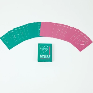 Close-up of 46 pink and green couple game cards with Sweet Commands gift box