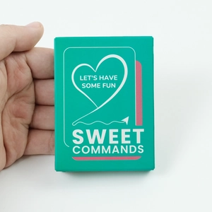 Close-up of Sweet Commands couple game card box with heart design and fun text